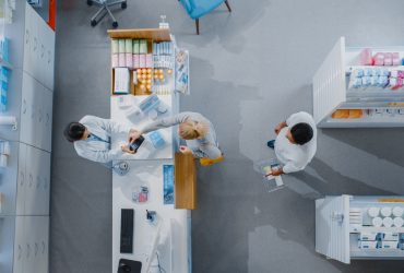 Vista de cima, de pessoa sendo atendida pelo farmacêutico em uma farmácia