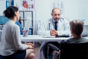 Mulher sendo atendida por médico, mas acompanhada por outra pessoa maior de idade