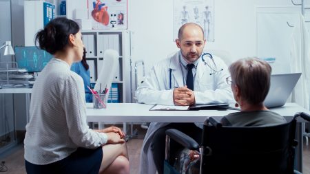 Mulher sendo atendida por médico, mas acompanhada por outra pessoa maior de idade