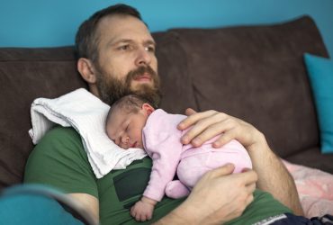 Pai cuidando da filha recém-nascida