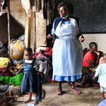 Um profissional de saúde num campo no sul do Malawi fala com pessoas deslocadas sobre medidas de prevenção da cólera | © UNICEF/Thoko Chikondi