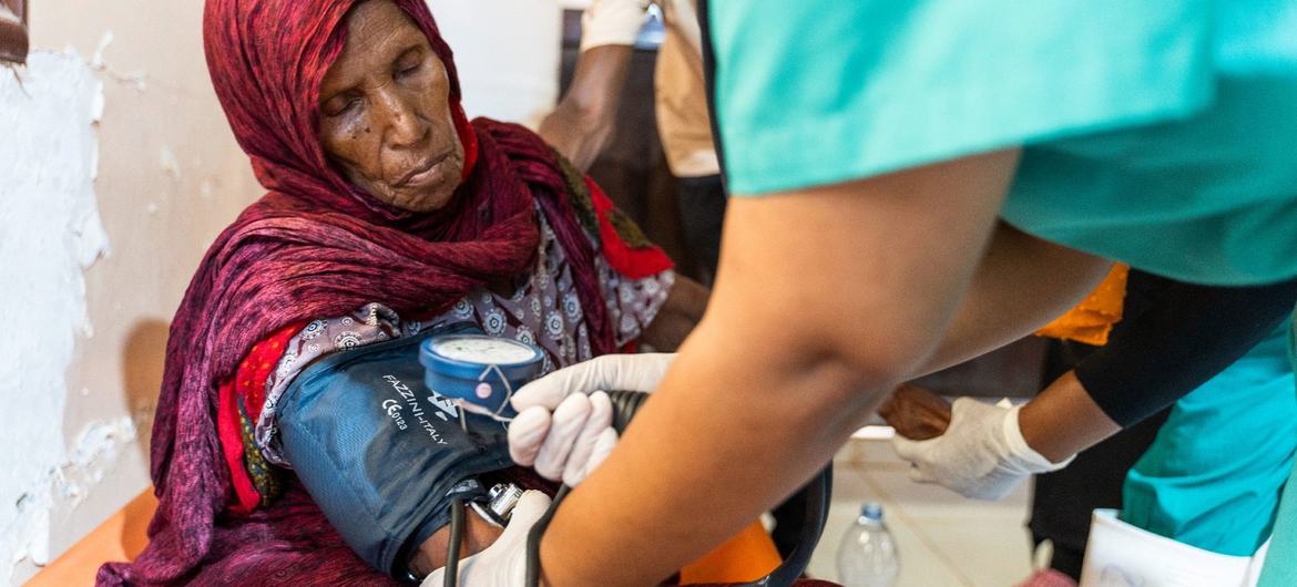 Uma mulher recebe cuidados médicos num centro de tratamento de cólera no Sudão | © OMS/Ala Kheir
