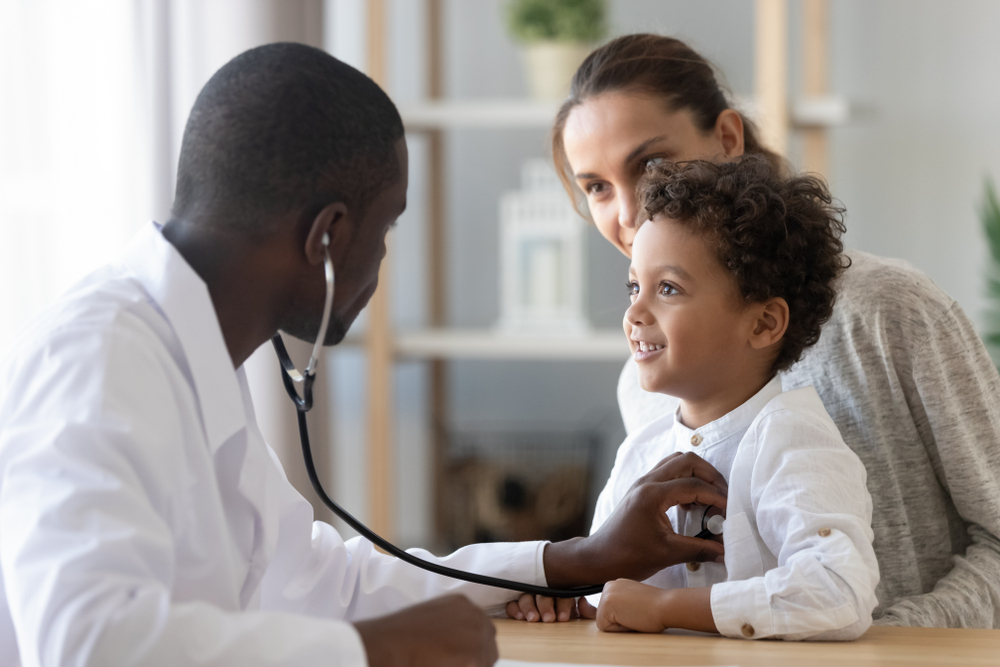 Criança sendo atendida por médico
