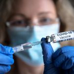 Profissional da saúde com uma dose da vacina contra o covid-19
