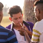 Grupo de adolescentes fumando cigarro com amigos Por diego_cervo