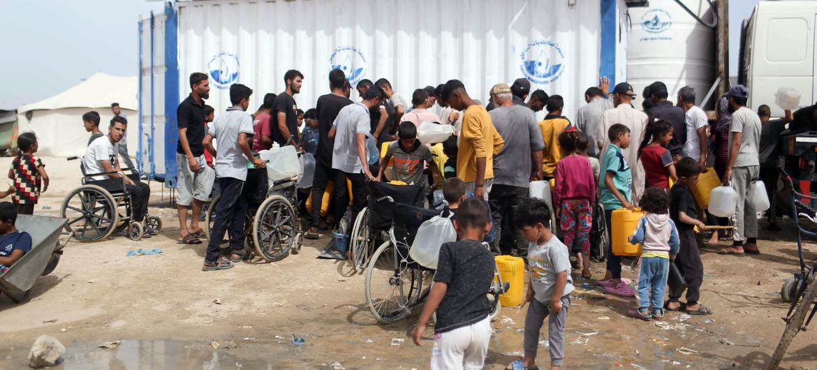 As pessoas em Rafah, no sul de Gaza, recolhem água potável | Foto de UNRWA