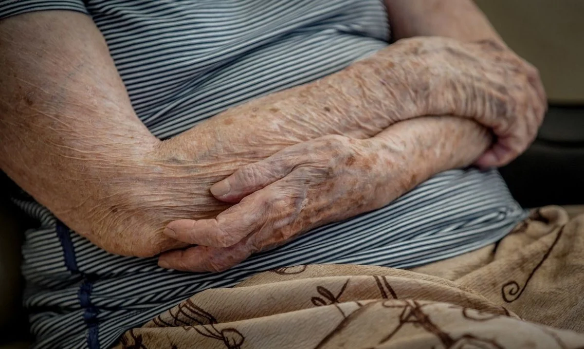 Os braços de uma pessoa idosa