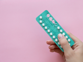 Mulher segura uma cartela de contraceptivo hormonal