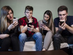 Um grupo de adolescentes olhando para os celulares