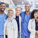 Retrato feliz, grupo e médicos pelo serviço de saúde, liderança e trabalho em equipe em um mergulhador hospitalar Por YuriArcursPeopleimages