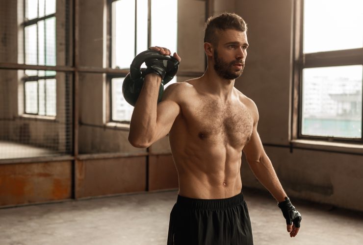 Homem sem camisa malhando com kettlebell Por kegfire