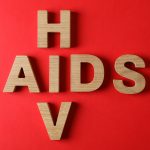 Palavras AIDS e HIV em fundo vermelho, espaço para texto Por AtlasComposer