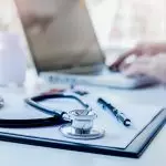 Médico realizando uma consulta utilizando o computador