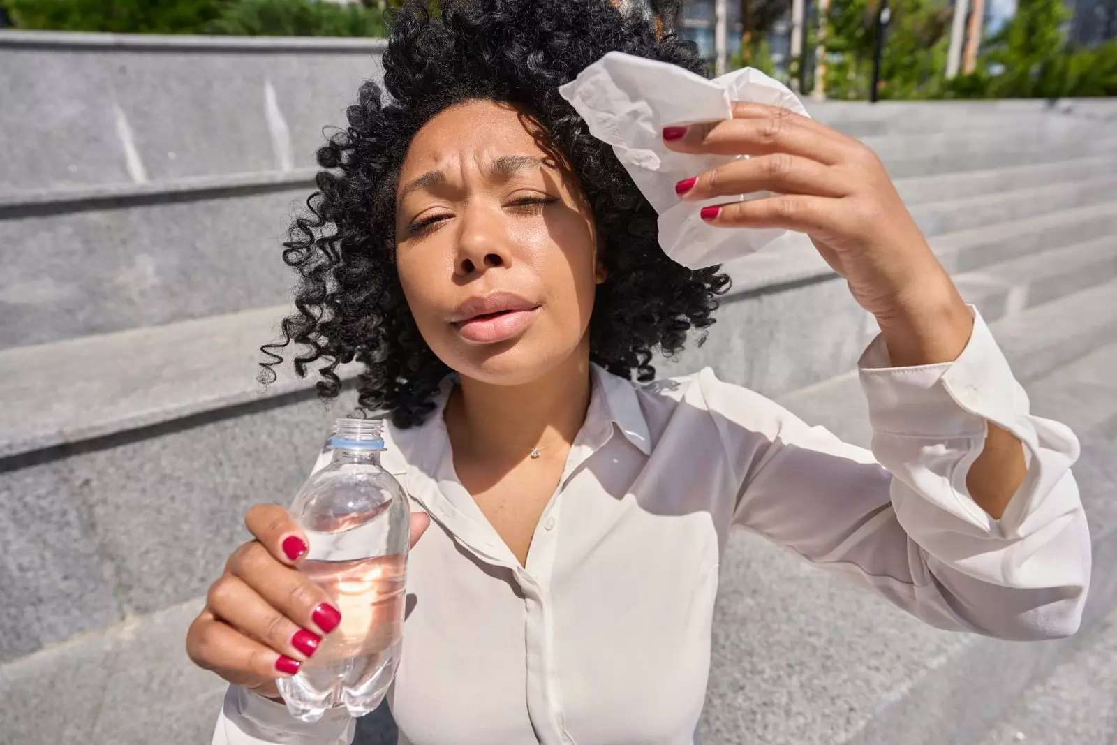 Mulher multirracial sentada na escada atormentada pelo calor intenso Por svitlanah