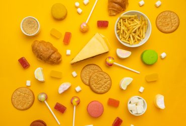 Variedade de lanches e doces em fundo amarelo. Alimentação não saudável Por shiwork