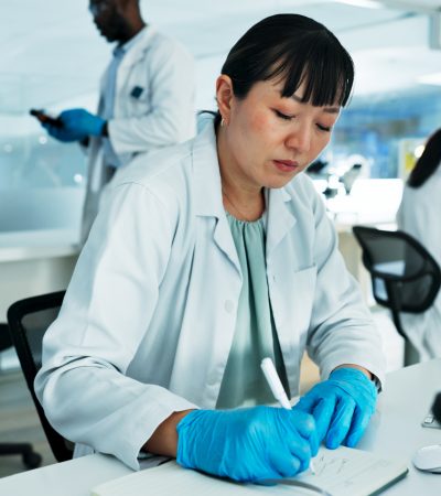 Cientista, mulher e escrevendo notas em laboratório com pesquisa médica, planejamento e solução na farmácia Por YuriArcursPeopleimages