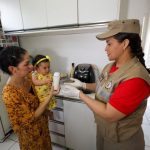 Imagem de uma mãe segurando sua bebê. As duas realizam a entrega do leite materno à Fundação Santa Casa, que tem parceria com o Corpo de Bombeiros Militar.