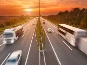 Foto panorâmica do tráfego de uma rodovia com ônibus e caminhões