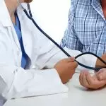 Médica medindo a pressão do paciente