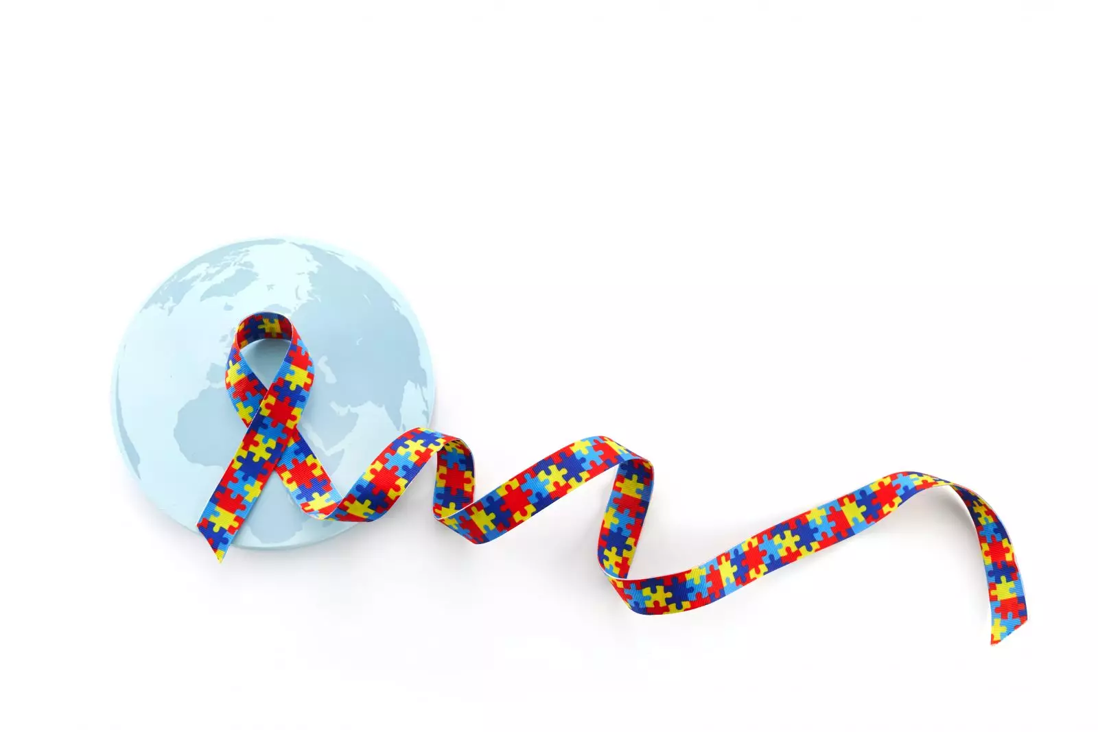 Dia ou mês mundial de conscientização e orgulho do autismo com fita padrão de quebra-cabeça em fundo branco Por vetre