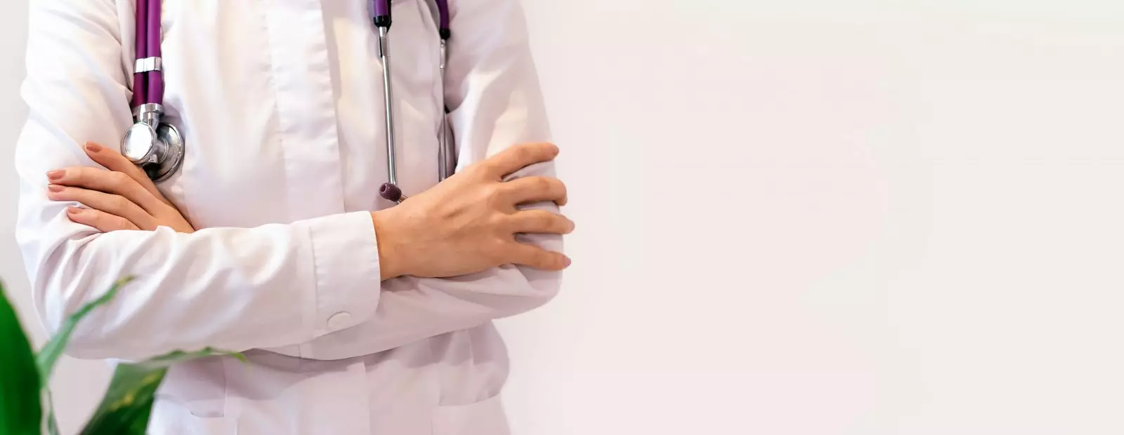 Médico de uniforme está com os braços cruzados sob o peito, sem rosto, close-up, conceito médico Por buzmakovatatyana