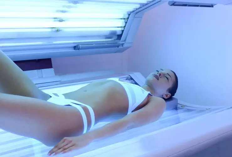 Mulher atraente se bronzeando no solário Por djile