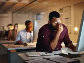 Foto de um jovem empresário parecendo estressado enquanto trabalhava até tarde em um escritório Por YuriArcursPeopleimages